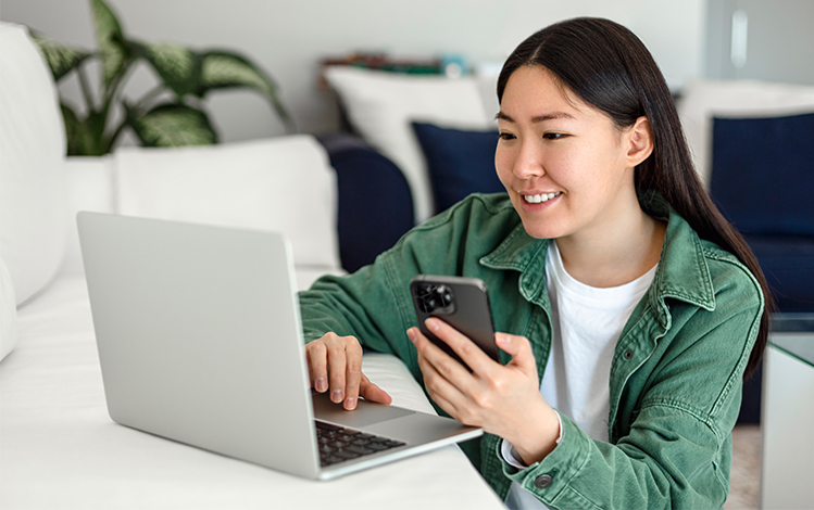 woman using laptop and phone