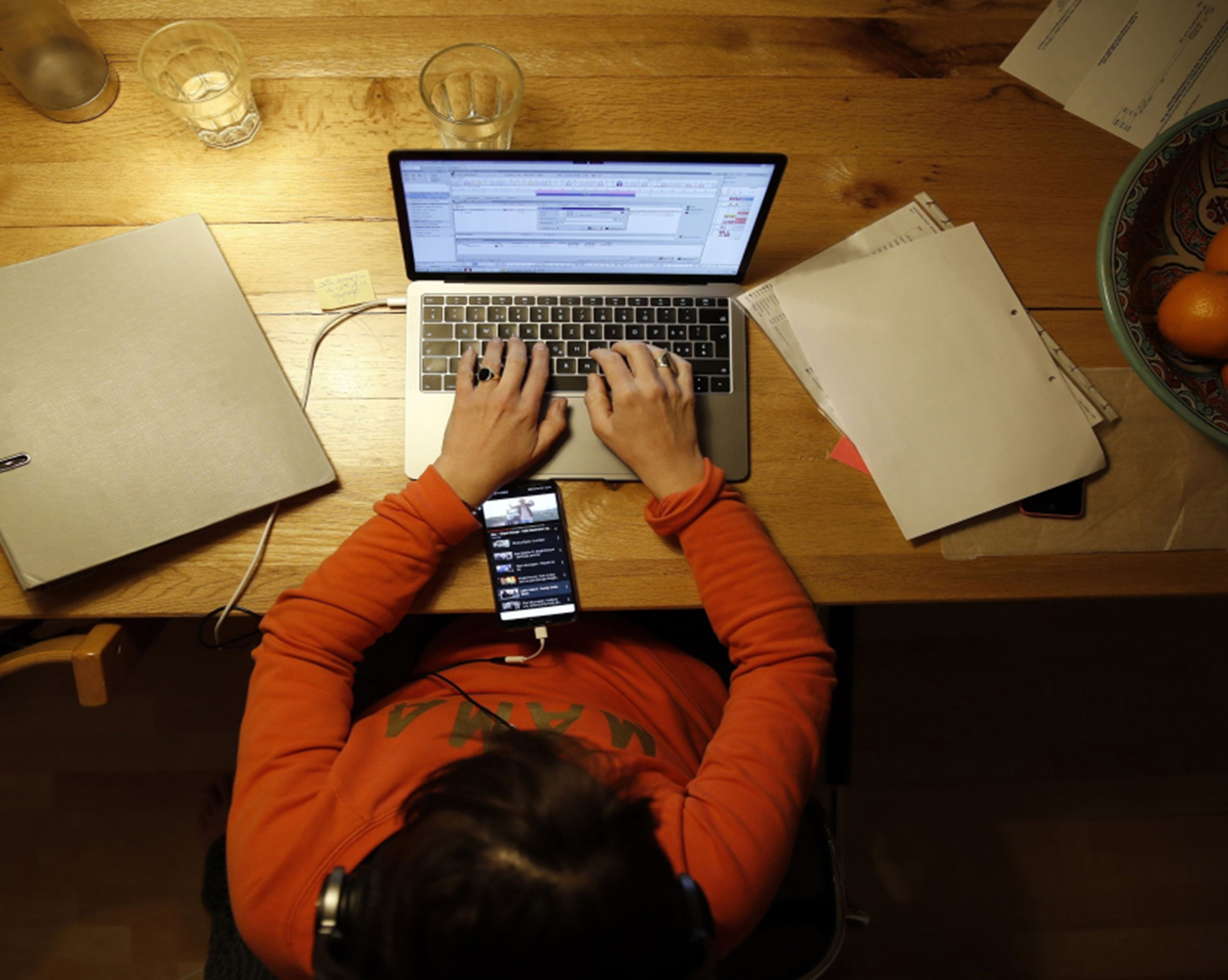 woman typing on laptop while listening to music