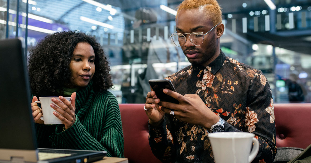 Two business people using a laptop and smartphone